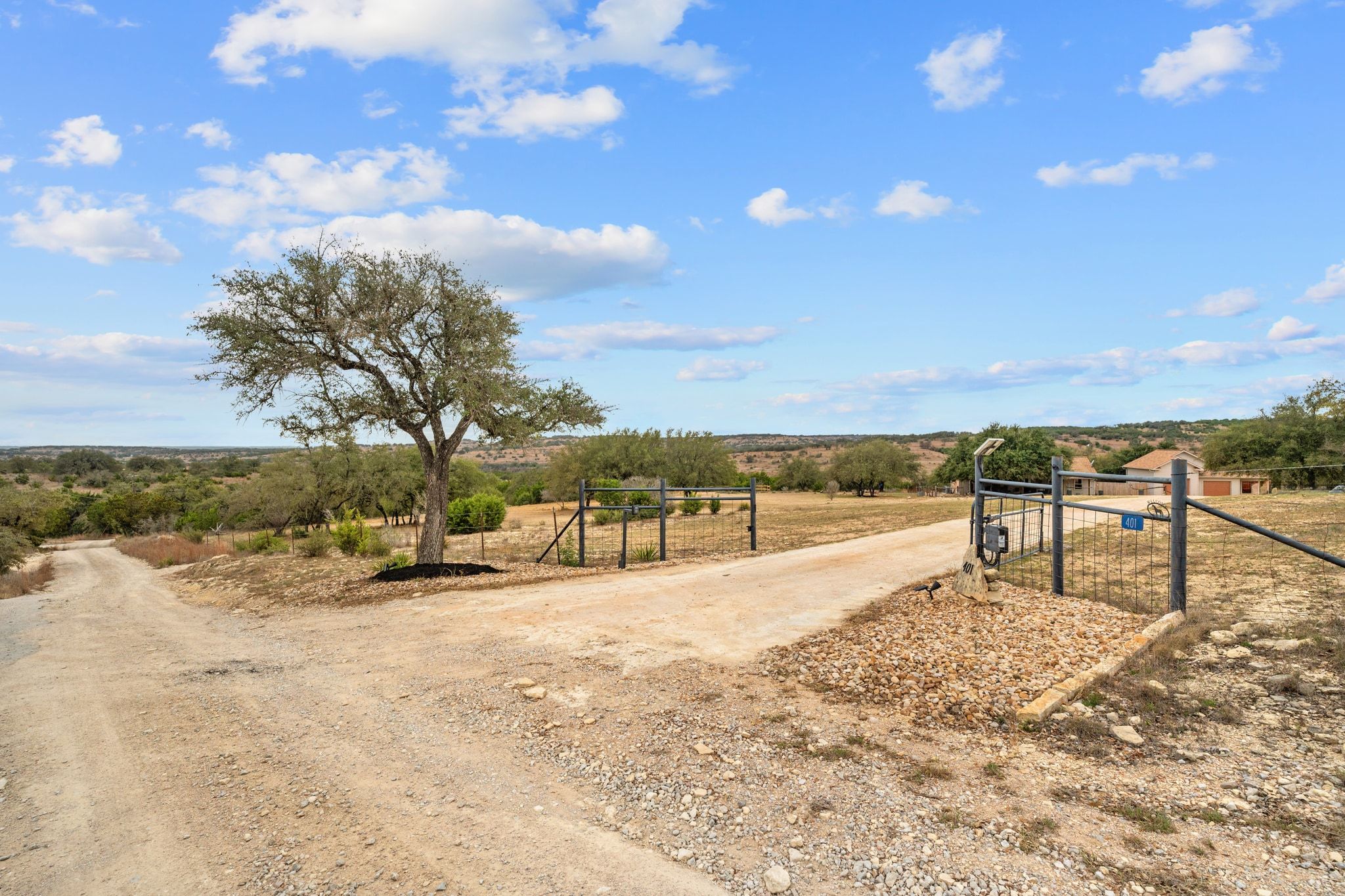 Custom electric gate w home set back under the trees for privacy