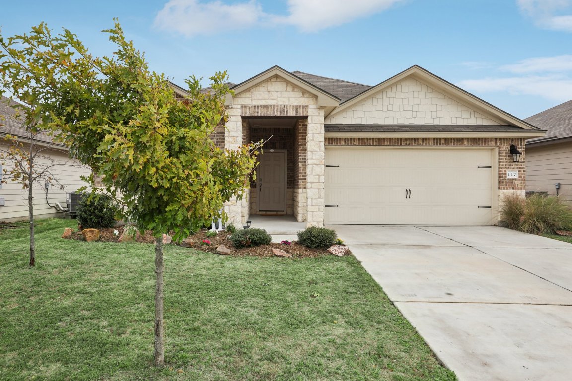 a front view of a house with a yard and garage