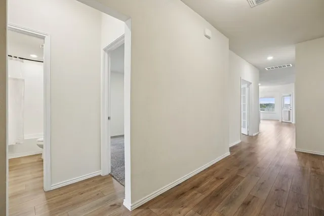 a view of a hallway with wooden floor