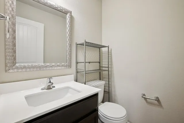 a bathroom with a sink toilet and mirror