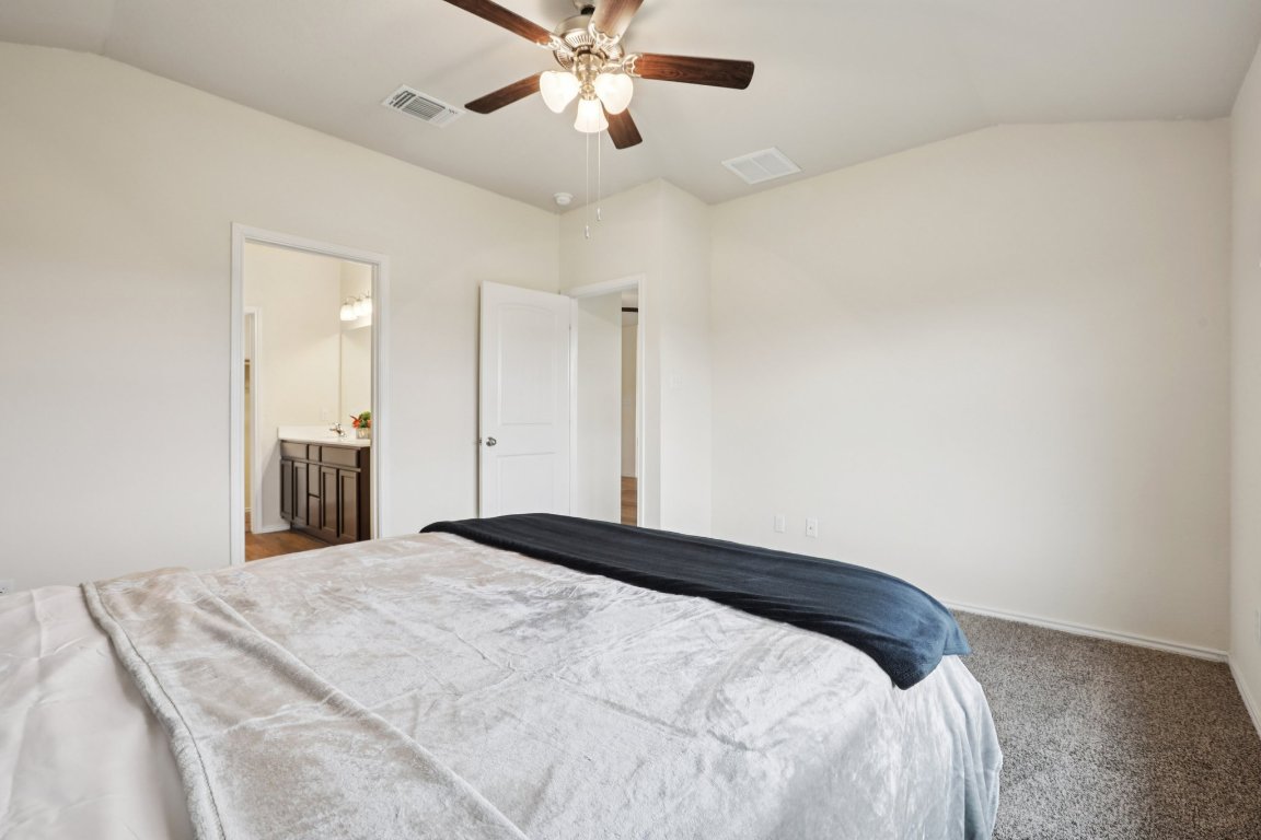 117 Break Avenue Taylor, TX 76574 - Photo 34 of 40 a bedroom with a bed and a chandelier