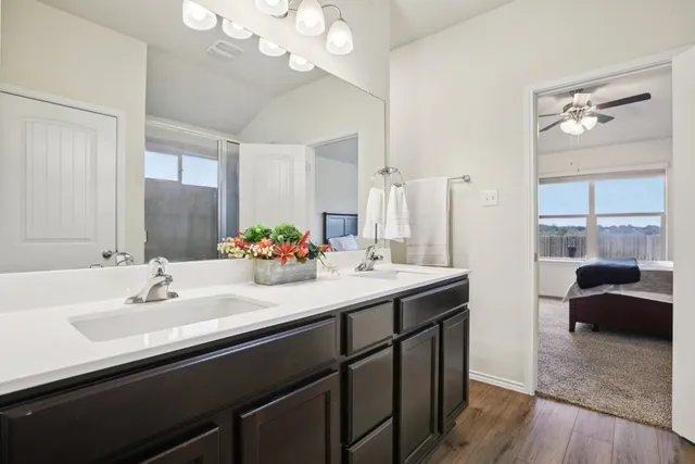 a en suite bathroom with a double vanity sink a mirror and a shower