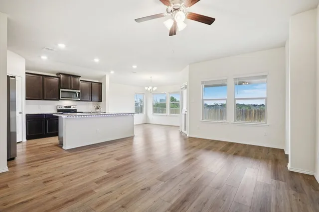 a view of kitchen with microwave a stove and wooden floor