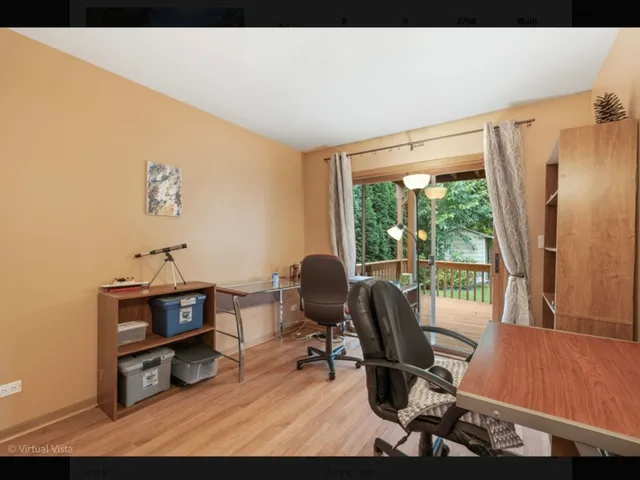a view of a workspace with furniture and a window