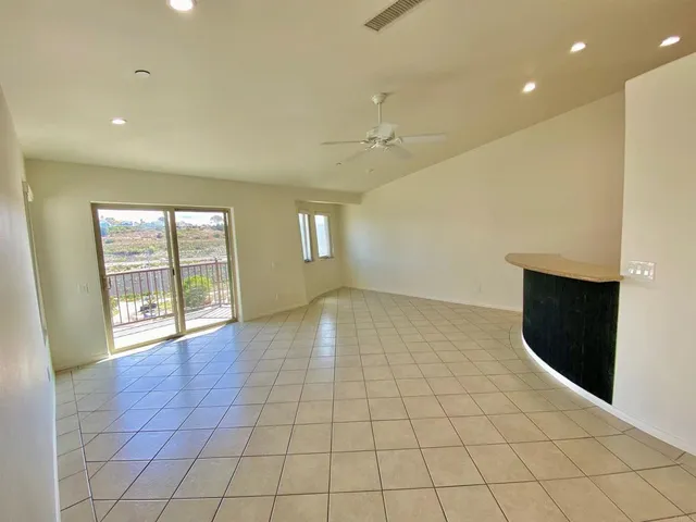 a view of a kitchen with a sink and an empty room