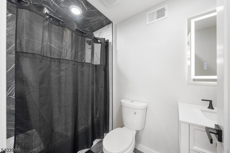 207 Post Avenue Lyndhurst, NJ 07071 - Photo 15 of 39 a bathroom with a toilet a sink and shower curtain