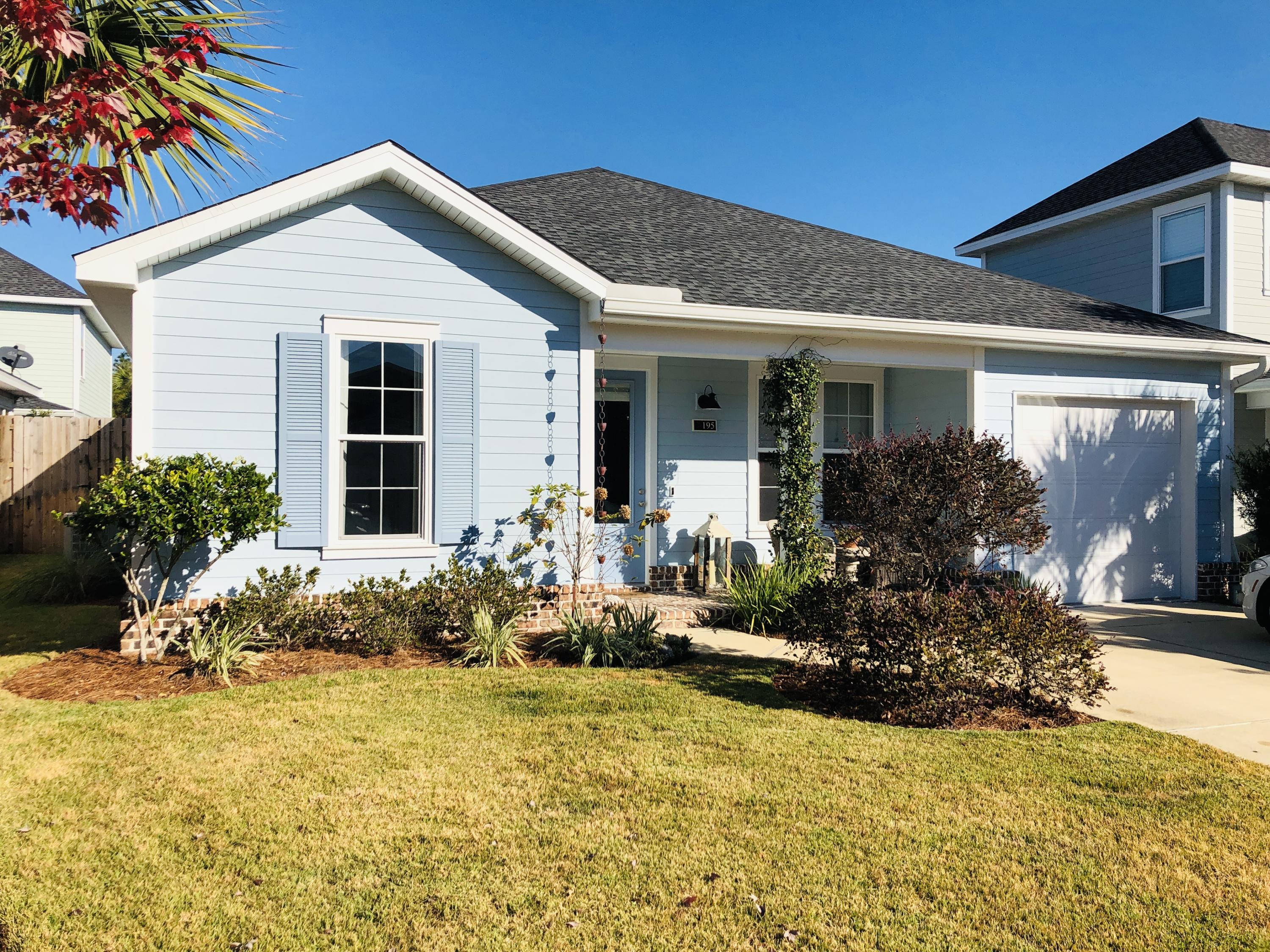 195 Chapman Street Santa Rosa Beach, FL 32459 - Photo 1 of 25 a front view of a house with a yard outdoor seating and plants