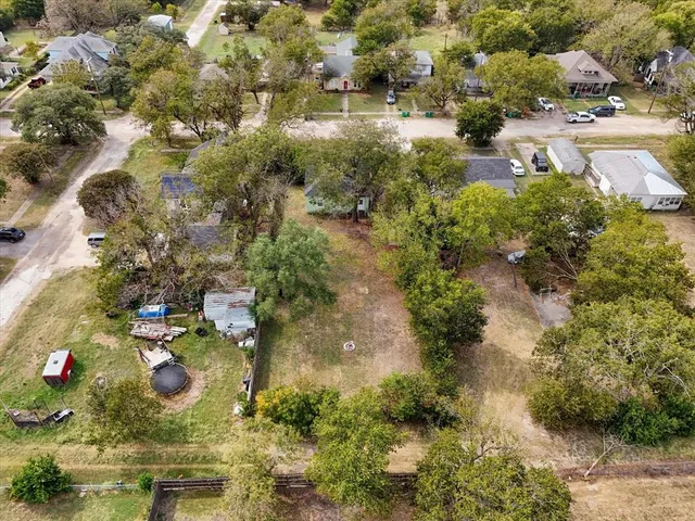 an aerial view of residential houses with outdoor space and trees