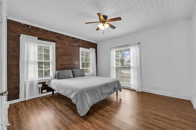 a bedroom with a large bed wooden floor and a window