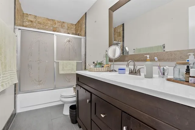 a bathroom with a double vanity sink toilet and shower