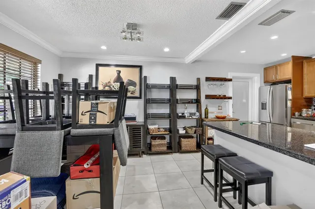 a kitchen with stainless steel appliances kitchen island granite countertop a refrigerator and cabinets
