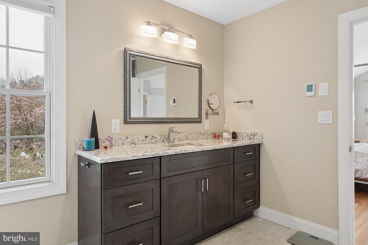 29 Dempsey Avenue Princeton, NJ 08540 - Photo 35 of 58 a bathroom with a granite countertop sink a large mirror a and a window
