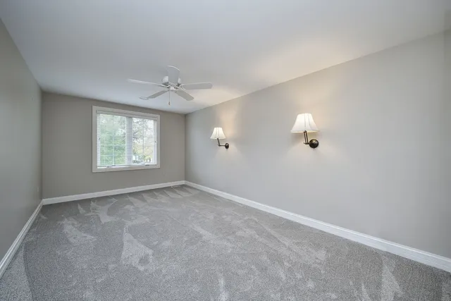 an empty room with windows and cabinet