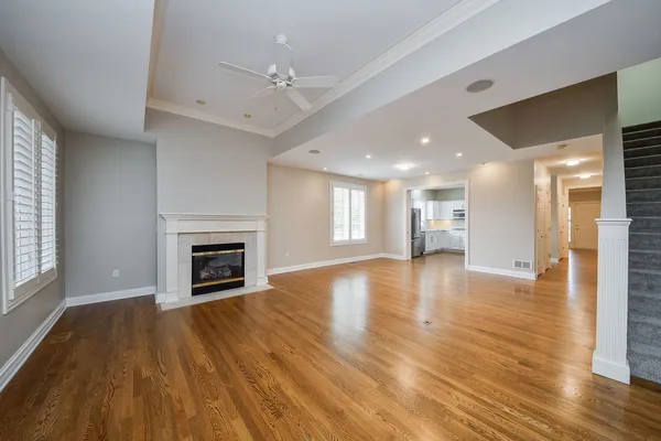 a view of empty room with wooden floor and fireplace