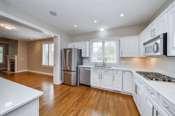 a kitchen with refrigerator cabinets and wooden floor