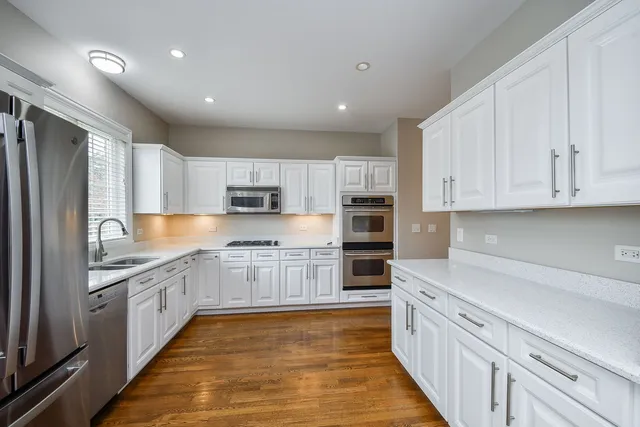 a large kitchen with stainless steel appliances granite countertop a large counter top and a stove top oven