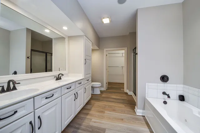 a spacious bathroom with a tub sink and mirror