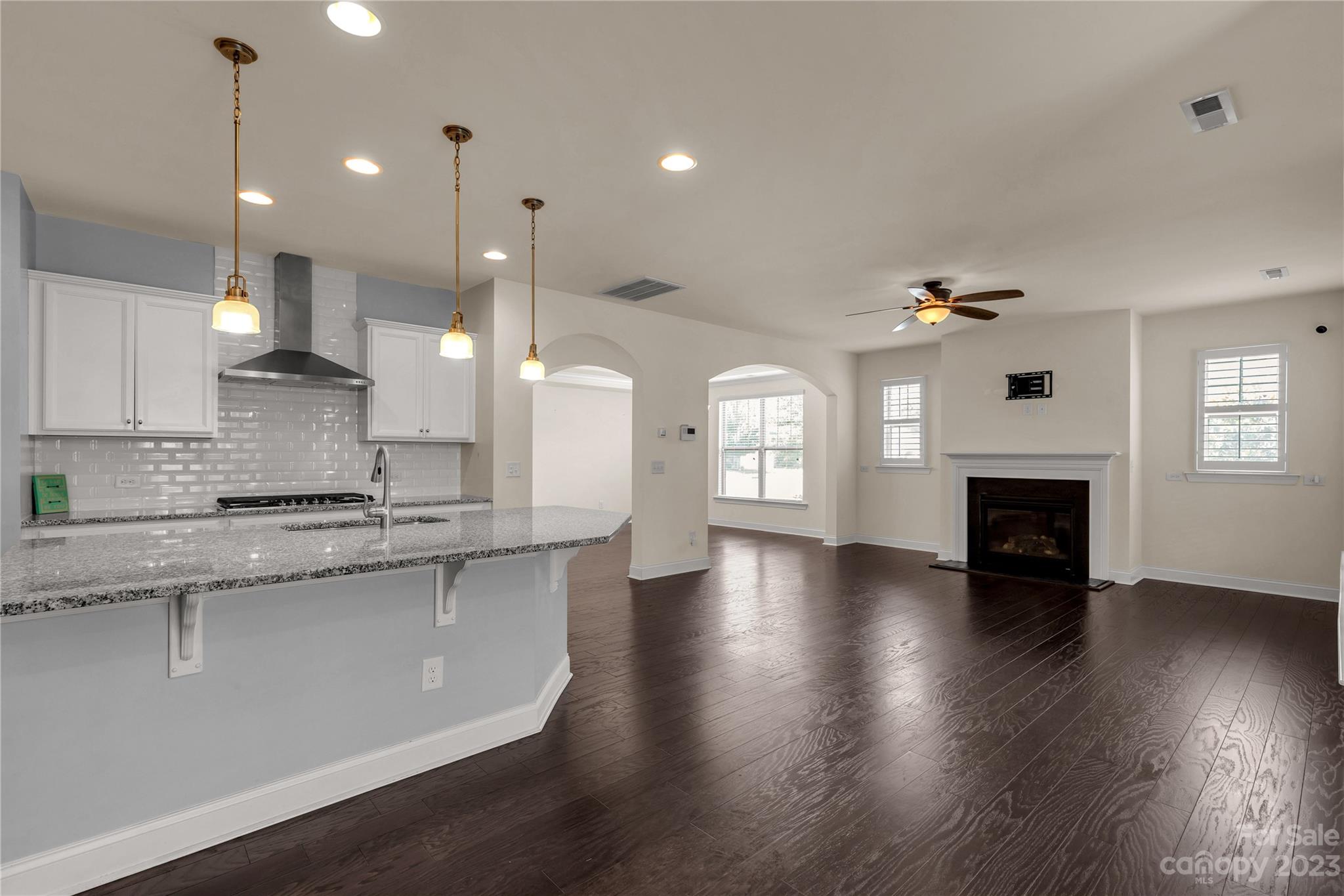 879 Pecan Tree Lane Fort Mill, SC 29715 - Photo 9 of 41 a large kitchen with granite countertop a stove top oven a sink dishwasher and a fireplace with wooden floor