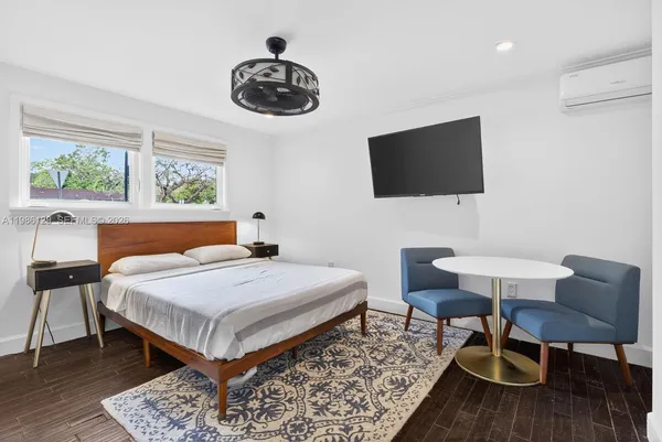 a bedroom with a bed a chair and a chandelier