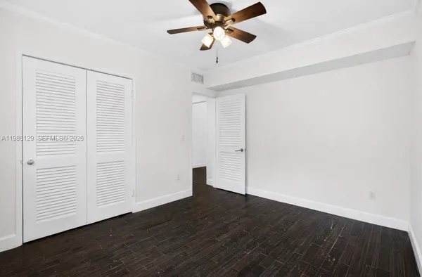 a view of a room with wooden floor and a ceiling fan