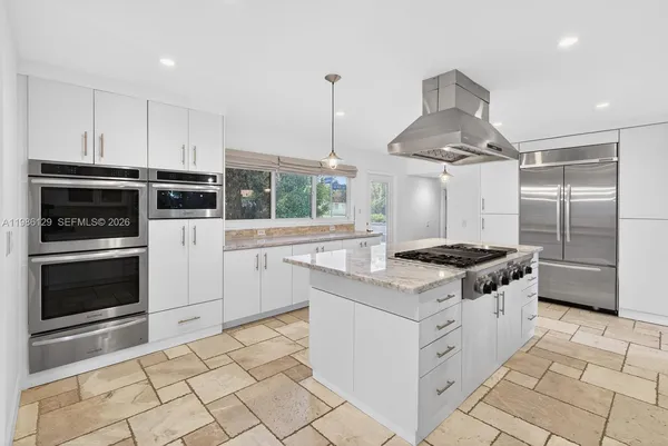 a kitchen with granite countertop a stove oven and sink
