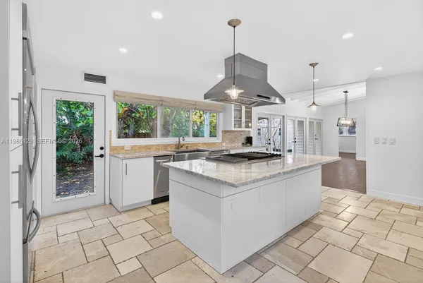 a kitchen with stainless steel appliances granite countertop a sink a stove and a refrigerator