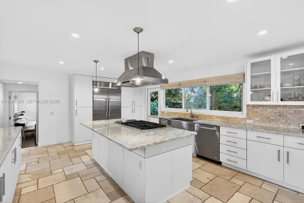 a kitchen with stainless steel appliances granite countertop a sink and a stove