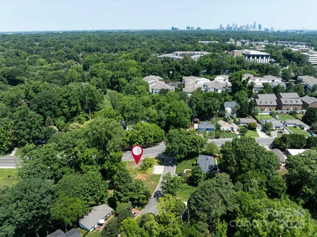 an aerial view of residential houses with outdoor space and trees all around