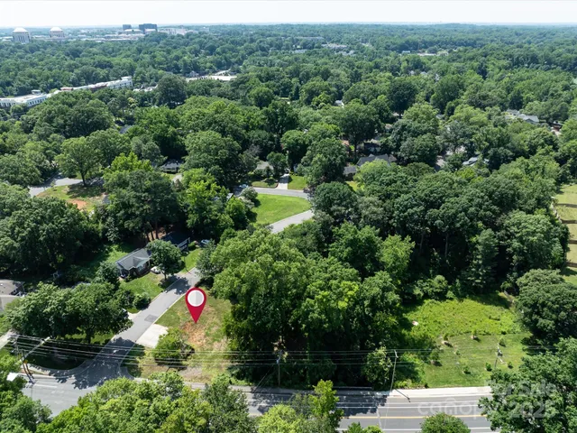 an aerial view of residential house with outdoor space and trees all around