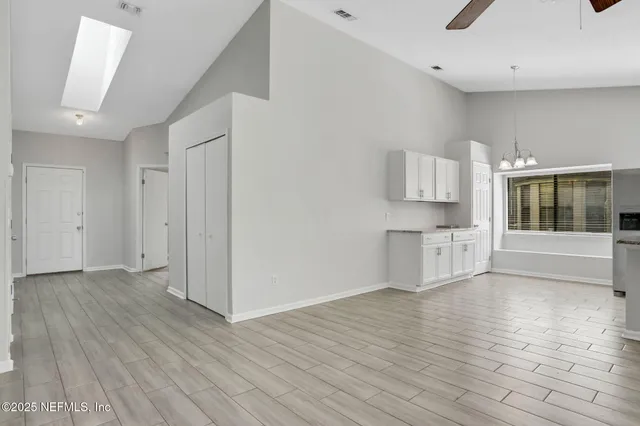 a view of an empty room with furniture and a ceiling fan