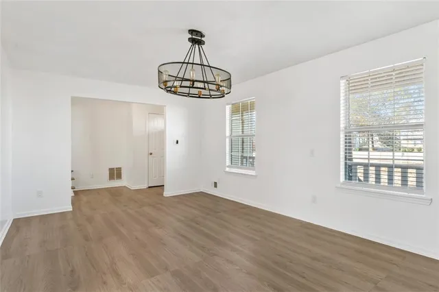 a view of big room with wooden floor and chandelier