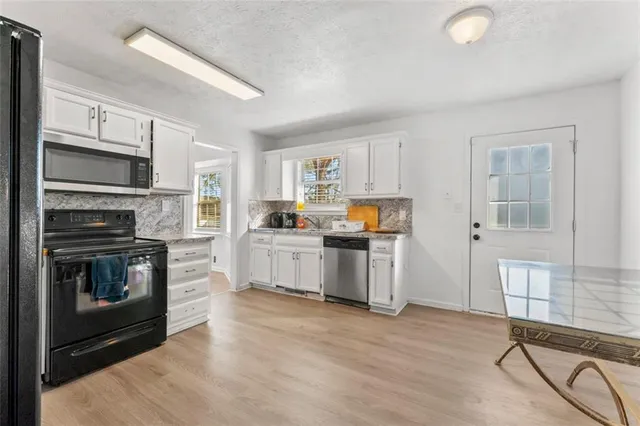 a kitchen with granite countertop a refrigerator and a sink