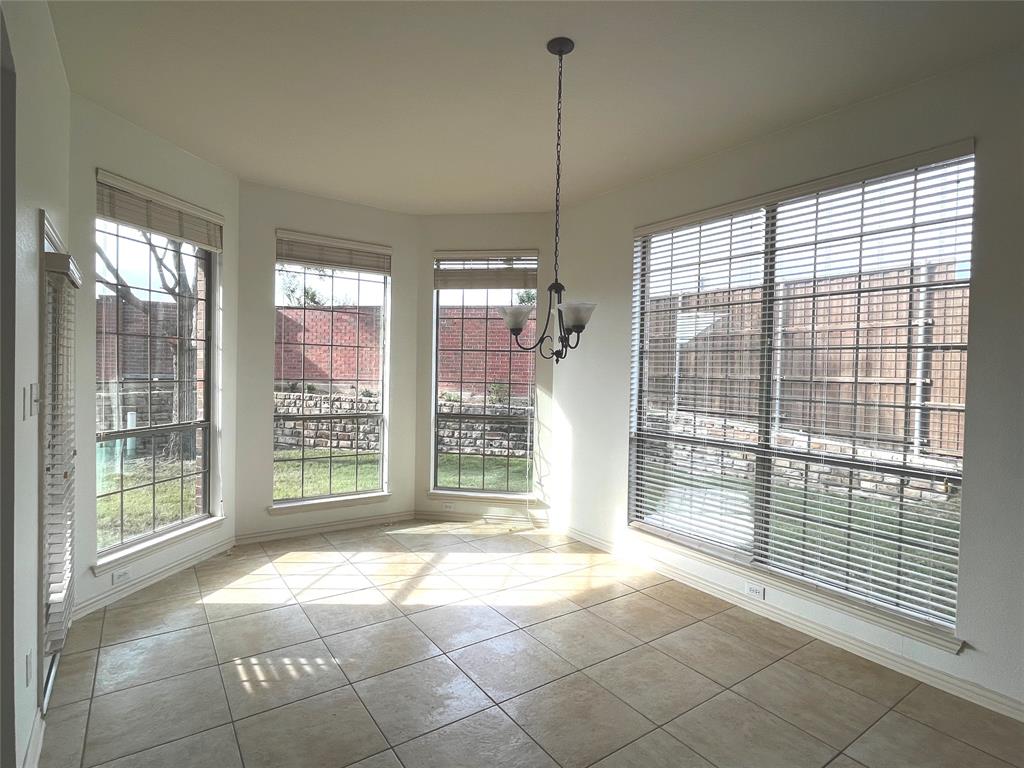 4101 White Porch Road Plano, TX 75024 - Photo 7 of 18 Bay window dining area featuring tile flooring, a chandelier, multiple windows with blinds, and white wall finishes