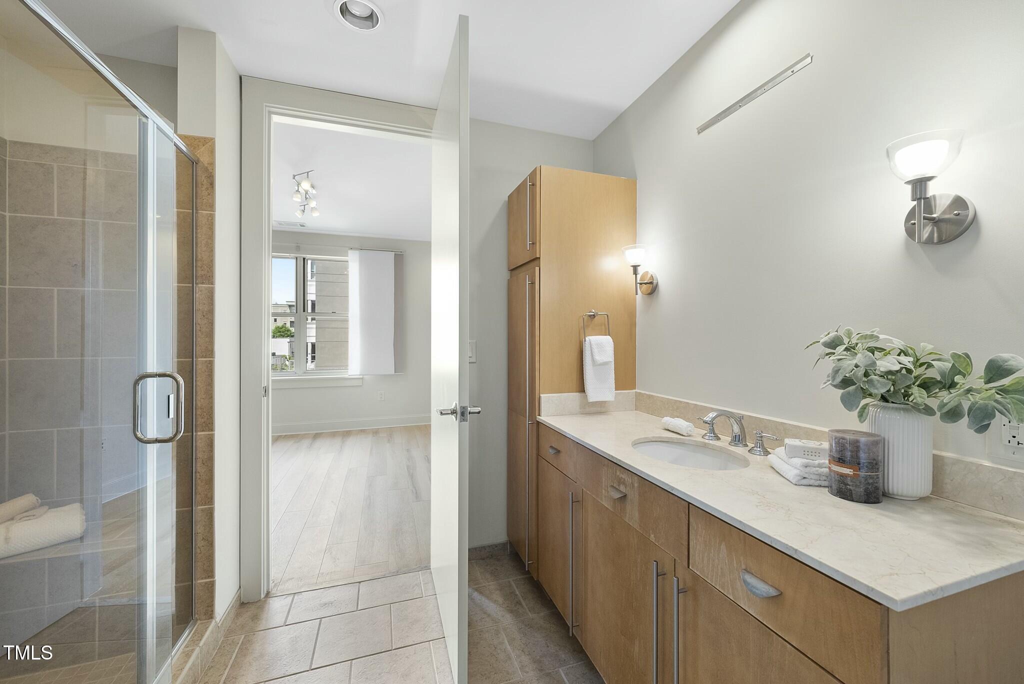 618 North Boylan Avenue, Unit 400 Raleigh, NC 27603 - Photo 14 of 28 a bathroom with a granite countertop sink a mirror and a shower
