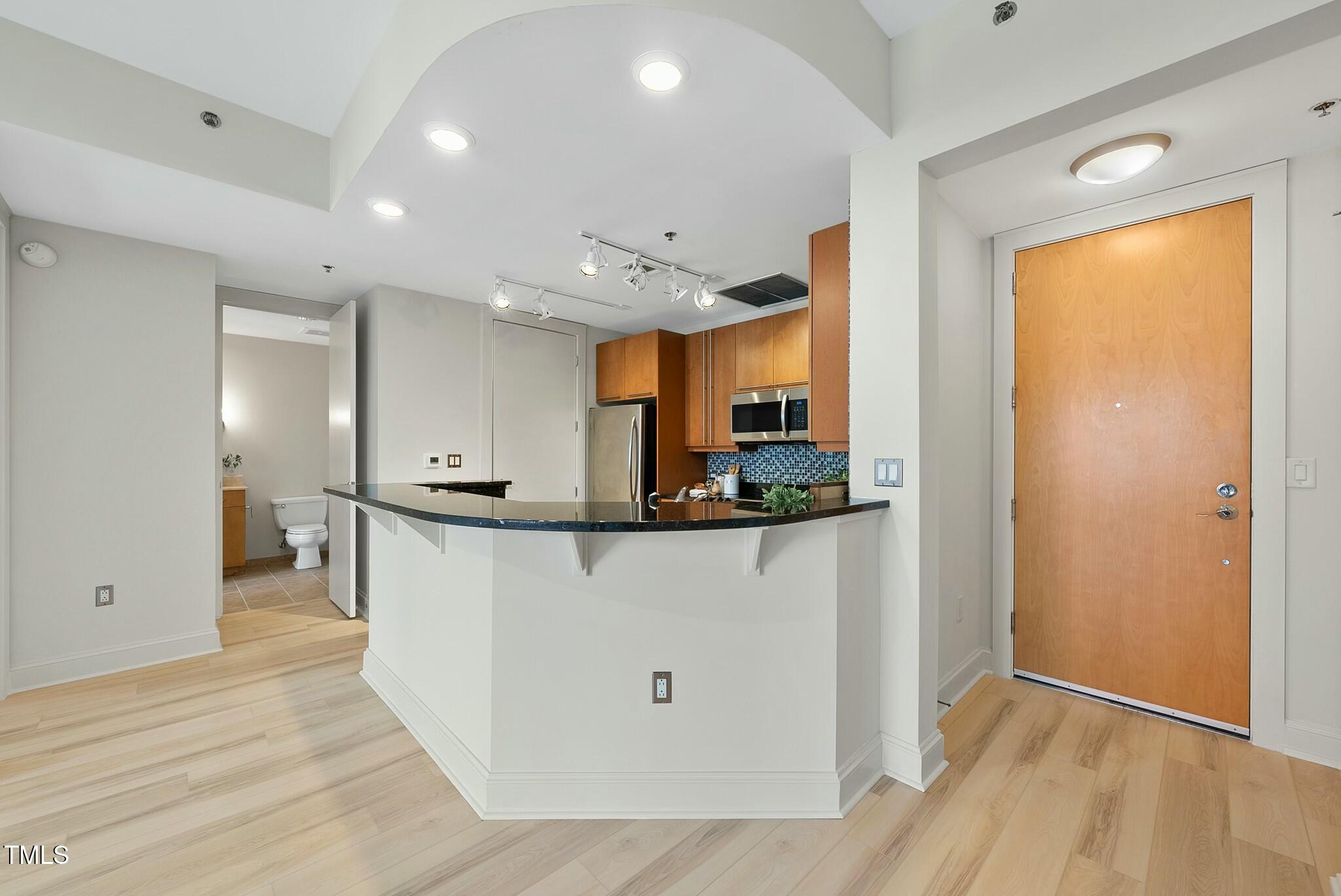 618 North Boylan Avenue, Unit 400 Raleigh, NC 27603 - Photo 5 of 28 a kitchen with stainless steel appliances granite countertop a refrigerator and a sink