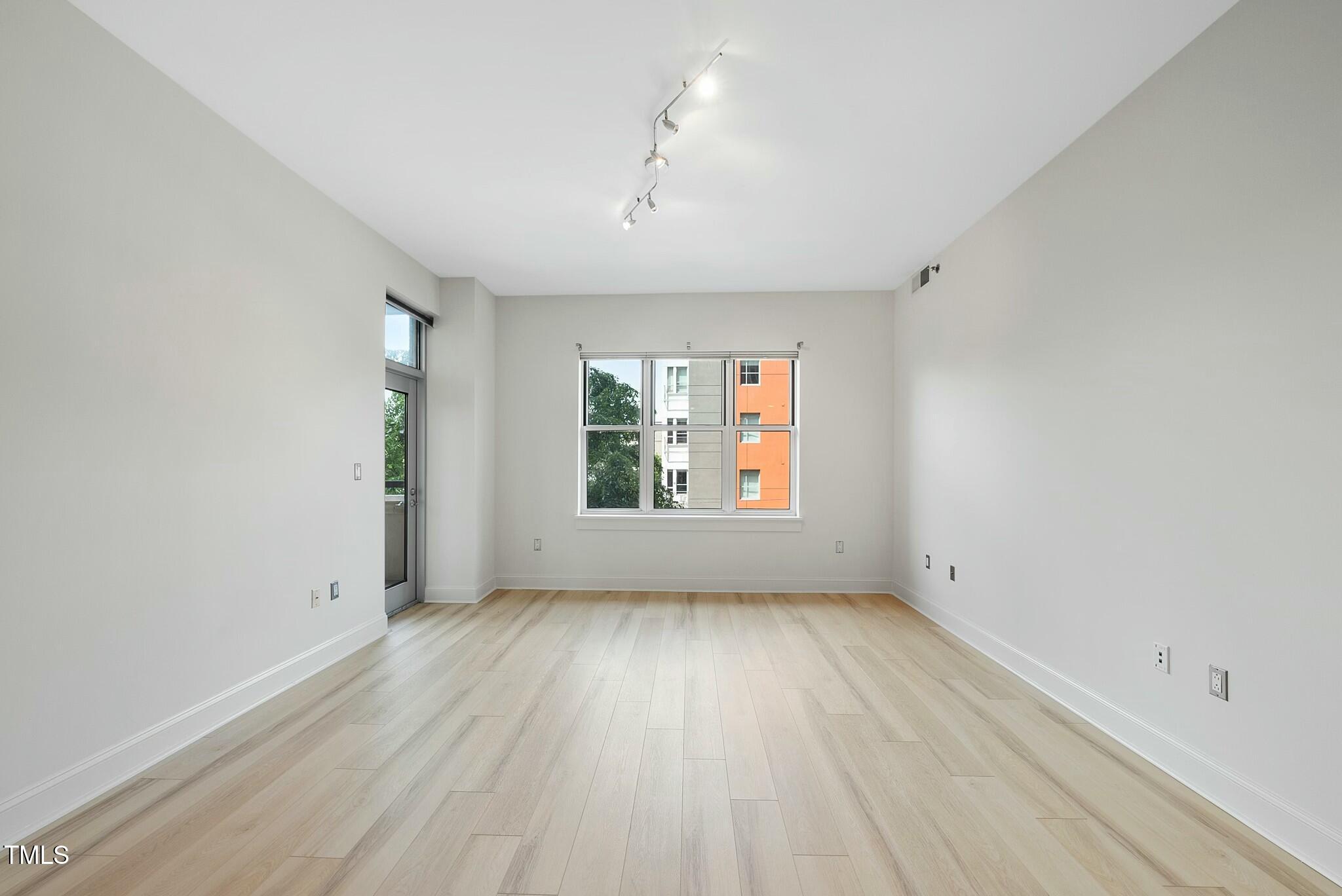 618 North Boylan Avenue, Unit 400 Raleigh, NC 27603 - Photo 6 of 28 an empty room with wooden floor and windows