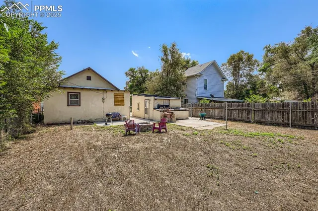 a backyard of a house with table and chairs