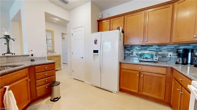 a kitchen with stainless steel appliances granite countertop a refrigerator and a sink