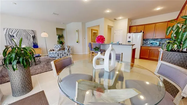 a dining room with furniture potted plants and wooden floor