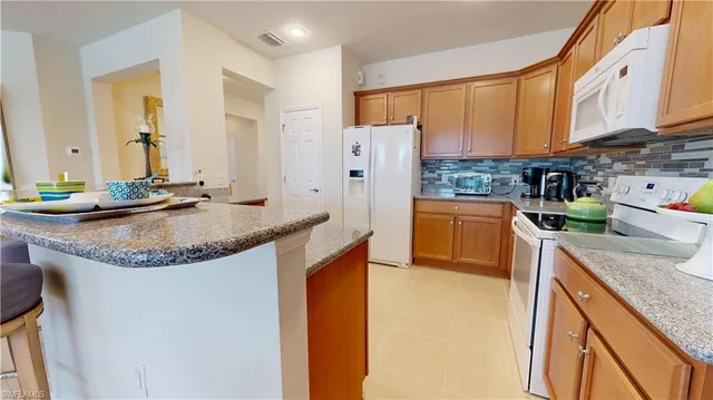 a kitchen with stainless steel appliances granite countertop a sink and a refrigerator
