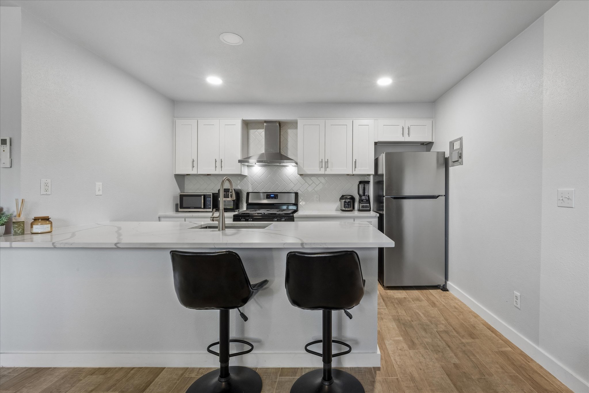 304 East 33rd Street, Unit 4 Austin, TX 78705 - Photo 4 of 15 Modern Bran new kitchen featuring white custom cabinetry, tile backsplash, Stainless steal dish washer, deep no divider sink, modern faucet, stove and hood.