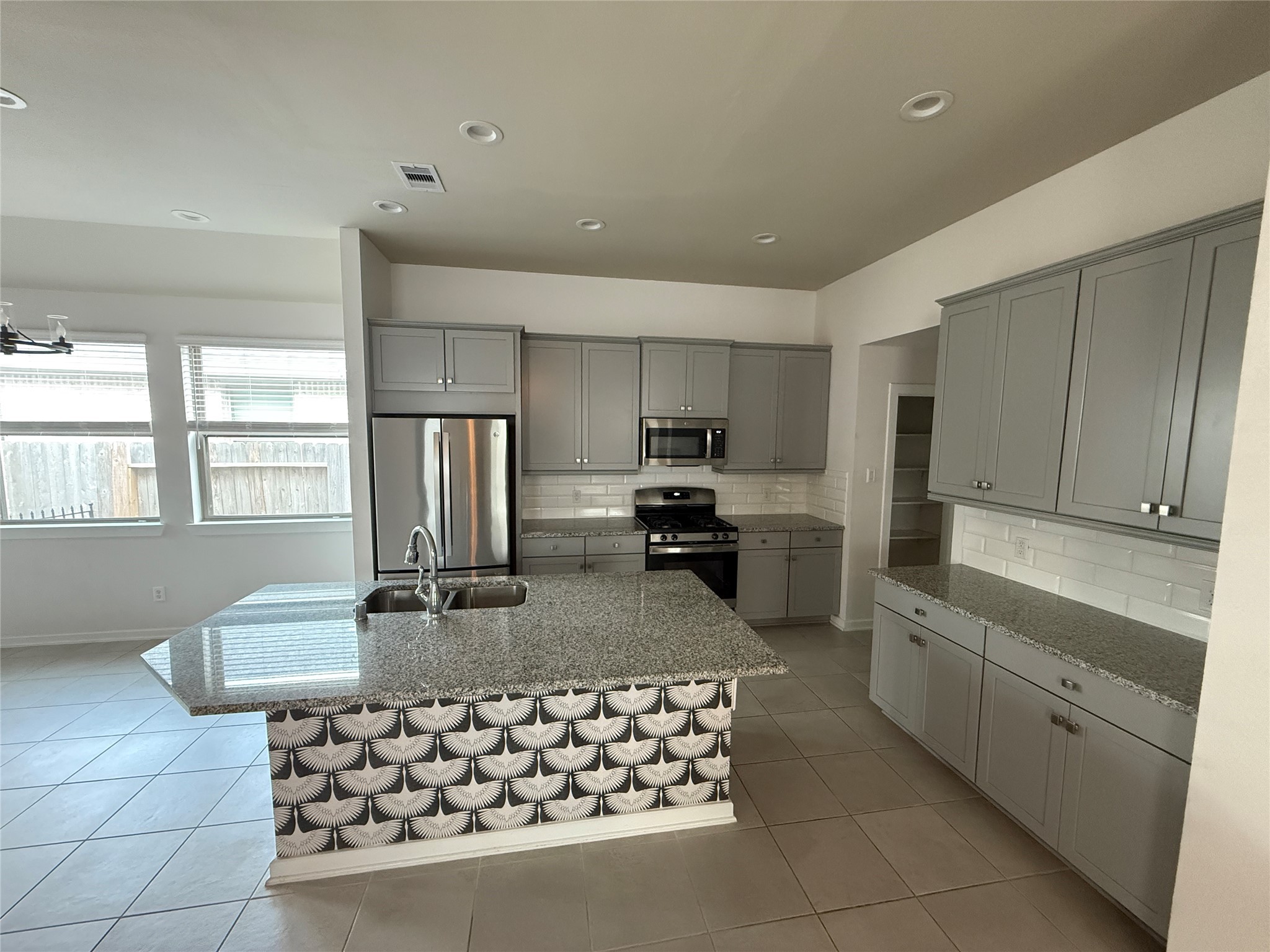 10534 Wild Chives Conroe, TX 77385 - Photo 6 of 24 a kitchen with stainless steel appliances granite countertop a sink stove refrigerator and cabinets