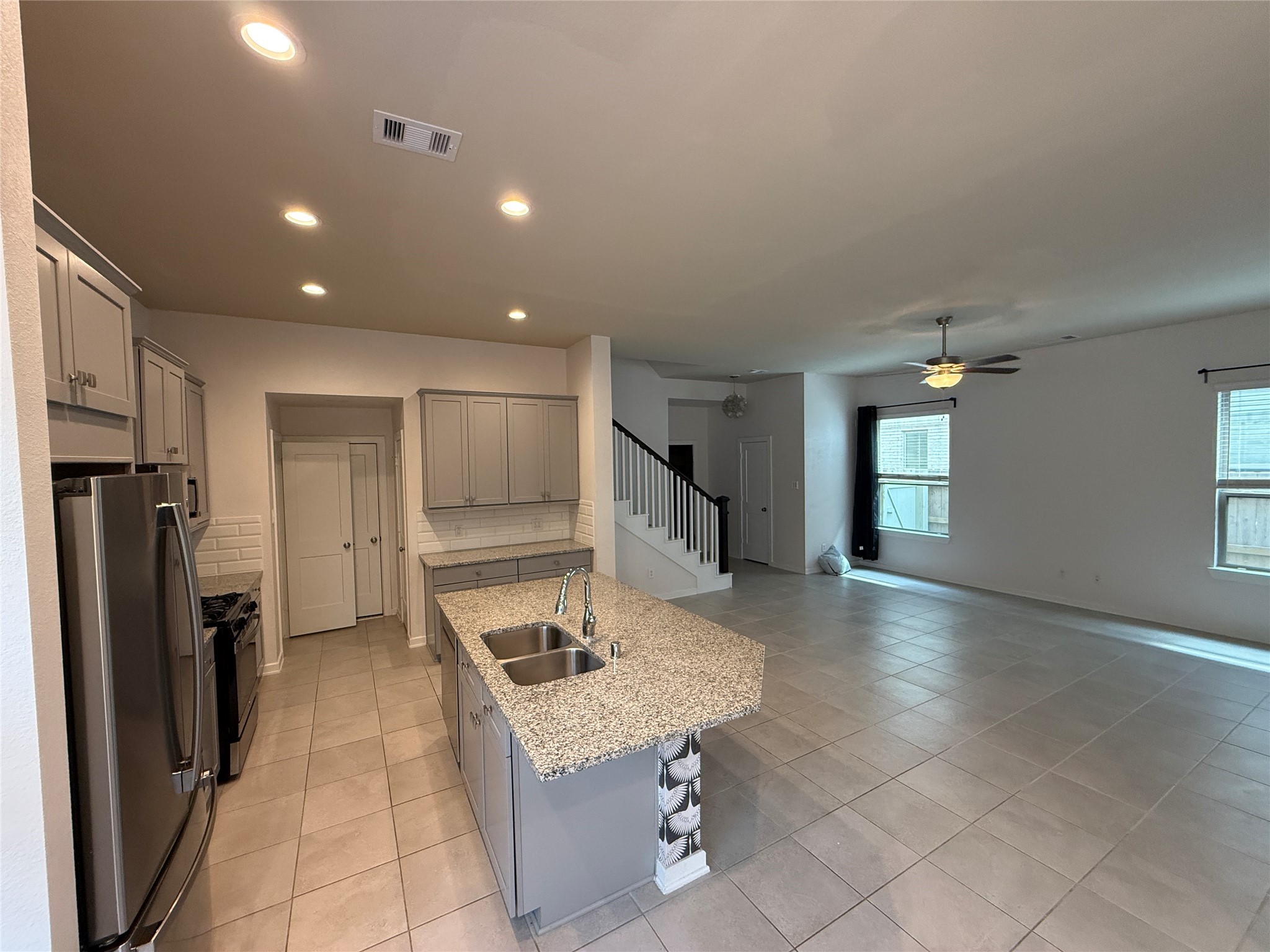 10534 Wild Chives Conroe, TX 77385 - Photo 7 of 24 a kitchen with stainless steel appliances kitchen island granite countertop a refrigerator and a sink