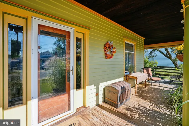 a view of a hallway with wooden floor and a living room
