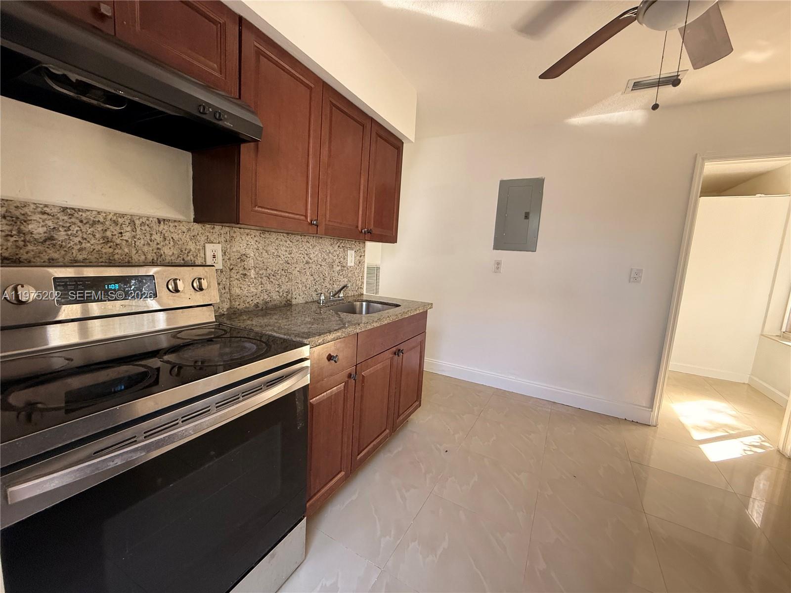 313 Northeast 57th Street, Unit 313 Miami, FL 33137 - Photo 1 of 13 a kitchen with stainless steel appliances granite countertop a stove a sink and a microwave