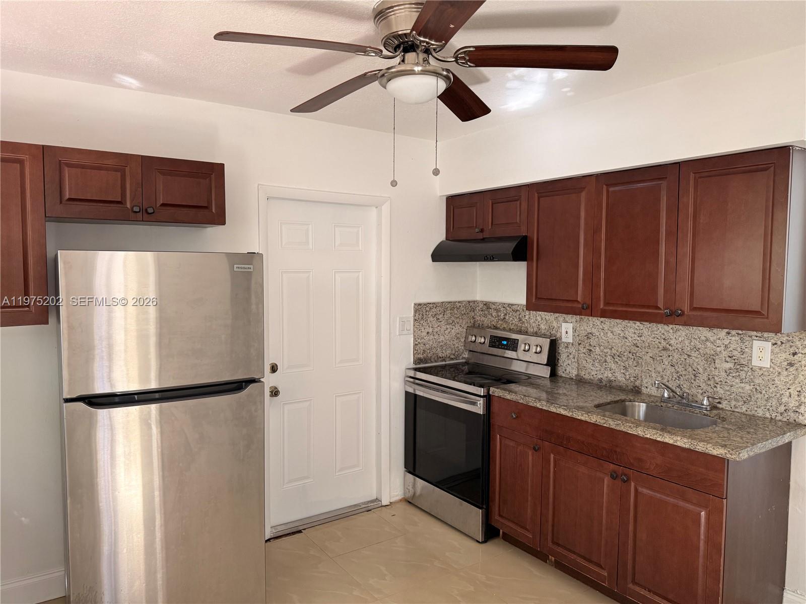 313 Northeast 57th Street, Unit 313 Miami, FL 33137 - Photo 2 of 13 a kitchen with stainless steel appliances granite countertop a refrigerator a sink and a stove