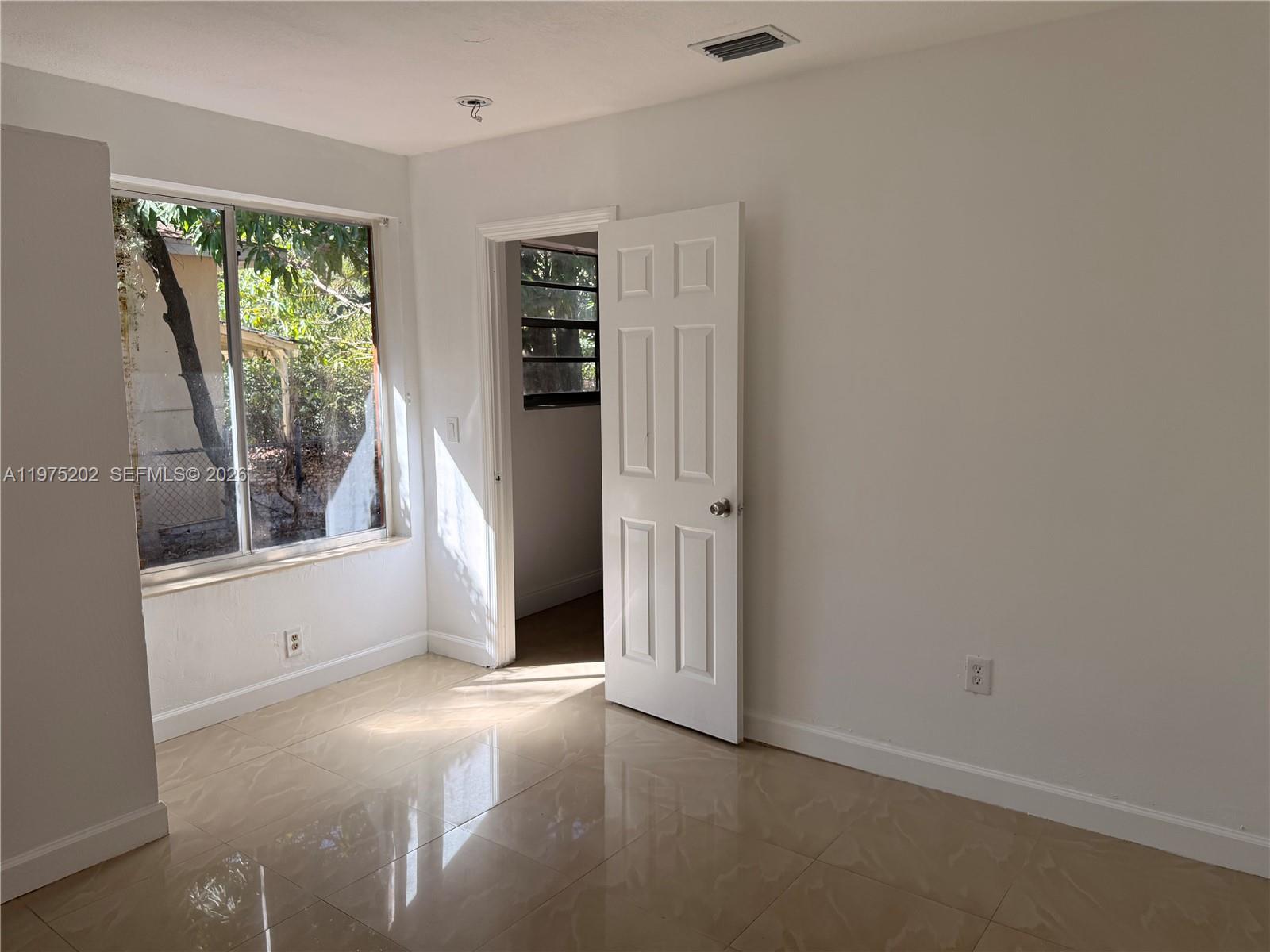 313 Northeast 57th Street, Unit 313 Miami, FL 33137 - Photo 3 of 13 an empty room with windows
