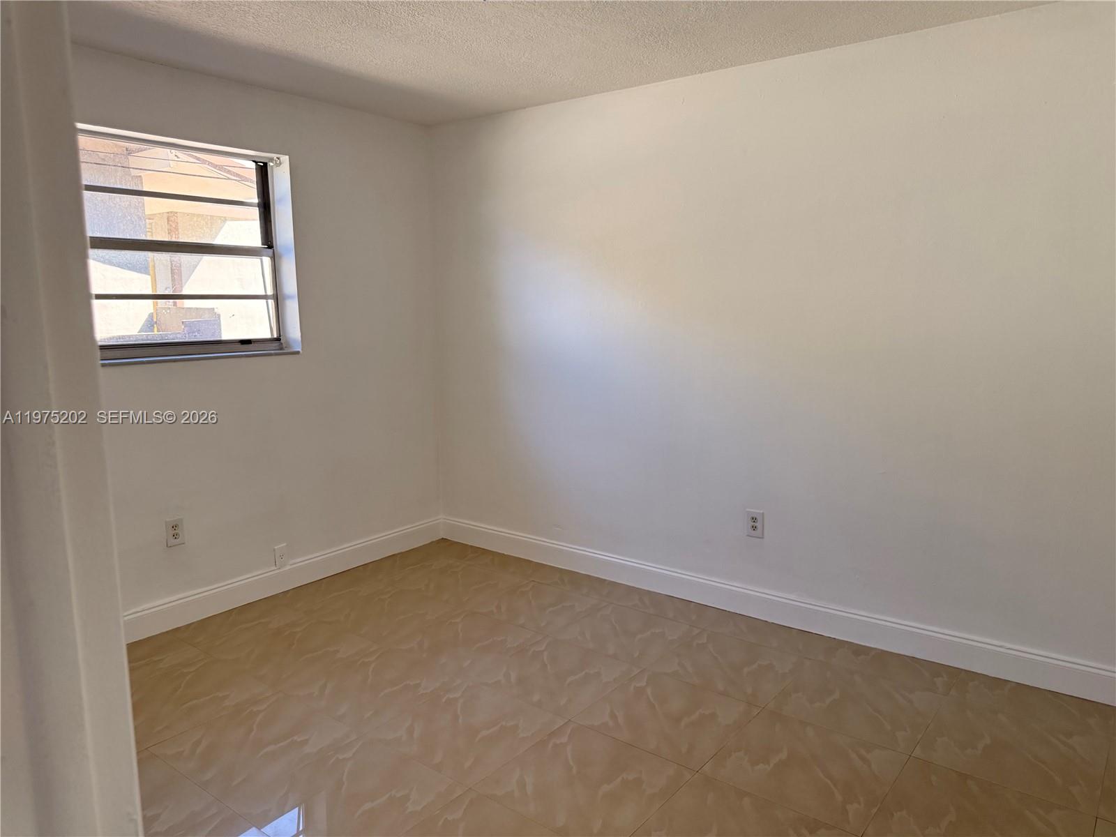 313 Northeast 57th Street, Unit 313 Miami, FL 33137 - Photo 4 of 13 an empty room with a window
