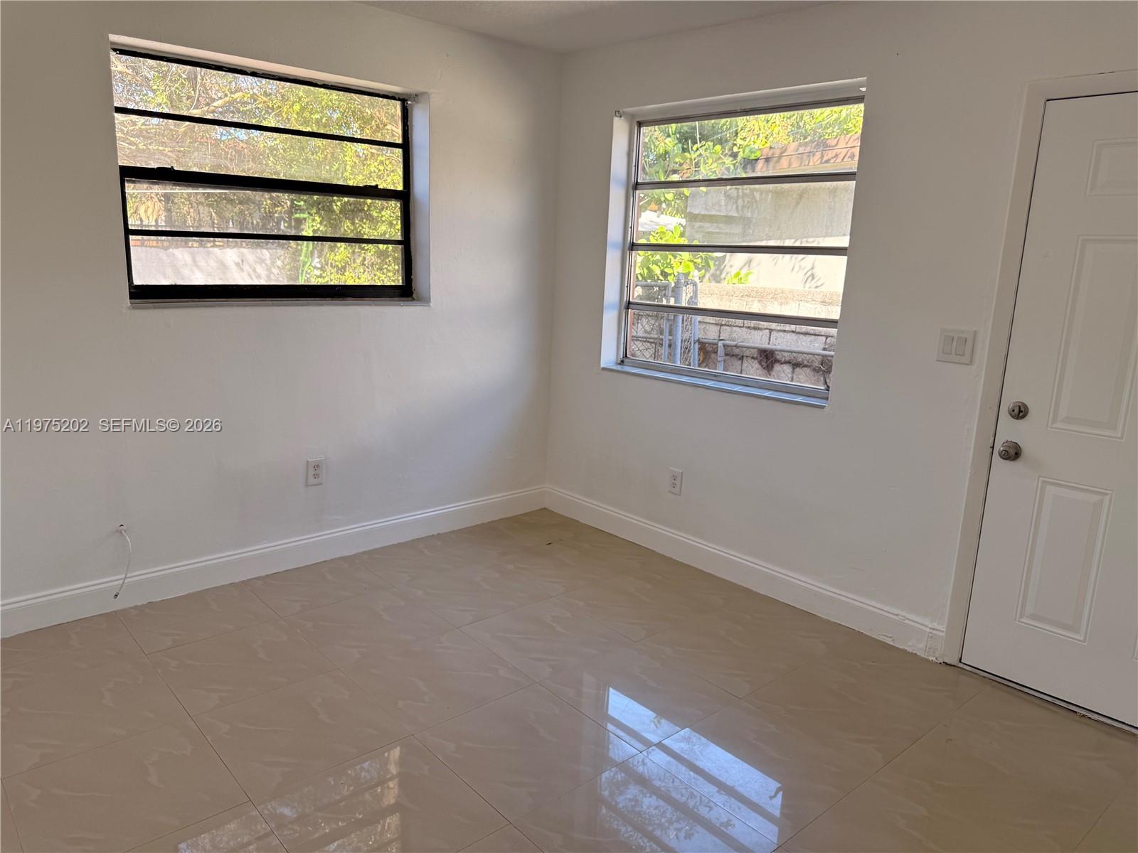 313 Northeast 57th Street, Unit 313 Miami, FL 33137 - Photo 5 of 13 an empty room with windows and closet