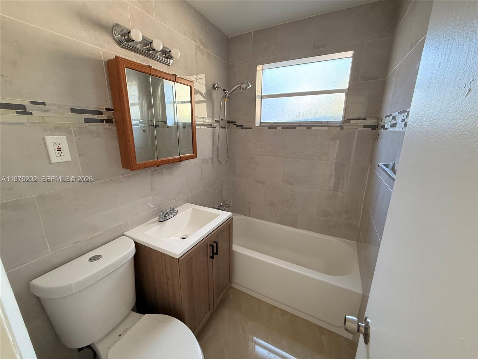 313 Northeast 57th Street, Unit 313 Miami, FL 33137 - Photo 7 of 13 a bathroom with a sink toilet and shower